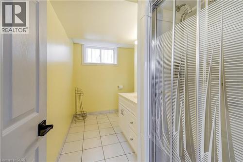 Three-piece bathroom featuring a shower with a patterned glass enclosure, a vanity with a light-colored countertop, and square floor tiles - 217 Lawnhurst Court, Hamilton, ON - Indoor Photo Showing Bathroom