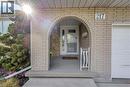Brick exterior featuring an arched entryway, concrete porch, and white decorative railing - 217 Lawnhurst Court, Hamilton, ON  - Outdoor With Exterior 