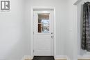 White paneled entry door with clear glass inserts, light grey wall paint, white trim, and wood-finish flooring - 149 Lottridge Street, Hamilton, ON  - Indoor Photo Showing Other Room 