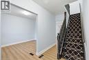 Staircase featuring dark wood newel posts and spindles, carpeted treads with a white and black geometric pattern, and a light wood-finish flooring - 149 Lottridge Street, Hamilton, ON  - Indoor Photo Showing Other Room 
