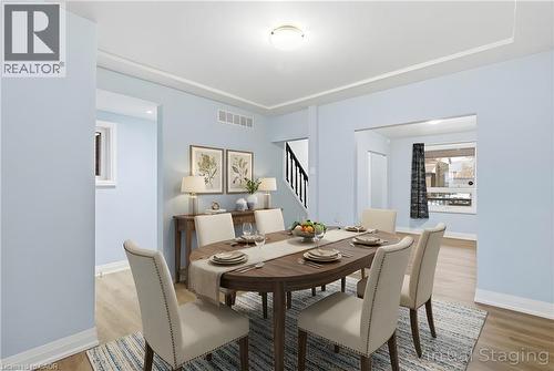 Open concept dining area featuring light blue walls, wood-finish flooring, and crown molding - 149 Lottridge Street, Hamilton, ON - Indoor Photo Showing Dining Room