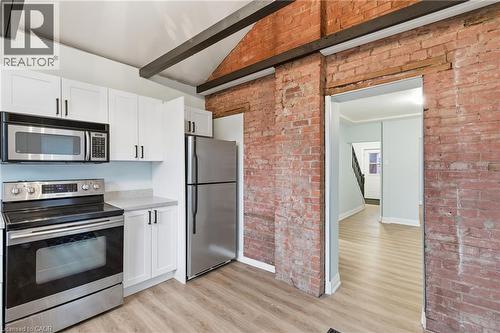 Kitchen featuring a stainless steel appliance suite, white cabinetry with black hardware, and light-toned countertops - 149 Lottridge Street, Hamilton, ON - Indoor Photo Showing Kitchen With Stainless Steel Kitchen