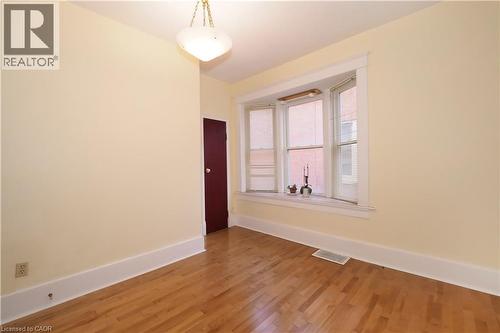 Hardwood flooring featuring a prominent bay window with white trim - 205 Duke Street E, Kitchener, ON - Indoor Photo Showing Other Room