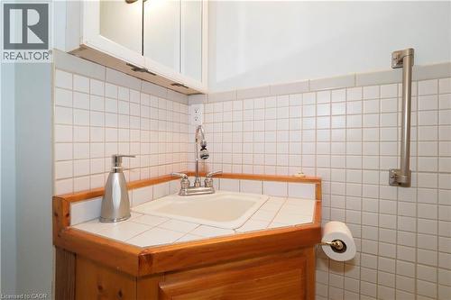 Corner vanity with wood cabinetry, tile countertop, and integrated sink - 205 Duke Street E, Kitchener, ON - Indoor Photo Showing Bathroom