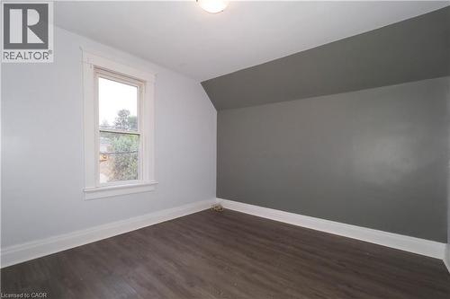 Room featuring wood-finish flooring, white baseboards, and a single window with white trim - 205 Duke Street E, Kitchener, ON - Indoor Photo Showing Other Room