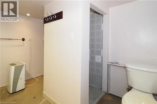 Bathroom area featuring a tiled shower stall and white toilet - 205 Duke Street E, Kitchener, ON - Indoor Photo Showing Bathroom