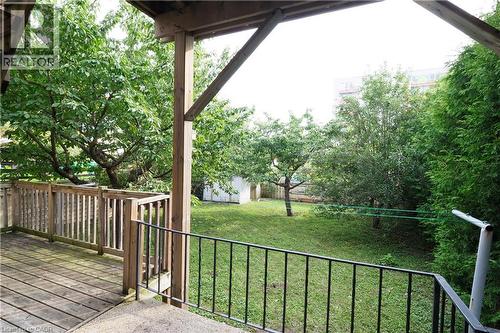 Elevated wood deck with railing overlooking a spacious green lawn - 205 Duke Street E, Kitchener, ON - Outdoor
