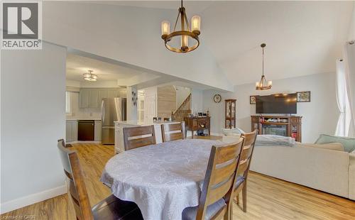 Open-concept living area featuring wood-finish flooring, vaulted ceilings, and a kitchen with stainless steel appliances - 512 Hidden Creek Drive, Kitchener, ON - Indoor Photo Showing Dining Room With Fireplace