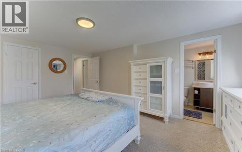 Carpeted bedroom with neutral wall tones and a ceiling-mounted light fixture - 512 Hidden Creek Drive, Kitchener, ON - Indoor Photo Showing Bedroom
