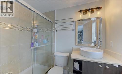 Bathroom featuring a glass-enclosed shower with tile surround and decorative mosaic accent band - 512 Hidden Creek Drive, Kitchener, ON - Indoor Photo Showing Bathroom