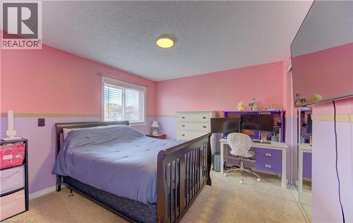 Carpeted room featuring a window with white blinds, a ceiling-mounted light fixture, and a built-in mirrored closet door - 512 Hidden Creek Drive, Kitchener, ON - Indoor Photo Showing Bedroom