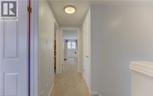 Hallway with carpet flooring, white paneled doors, and a flush mount ceiling light fixture - 512 Hidden Creek Drive, Kitchener, ON - Indoor Photo Showing Other Room