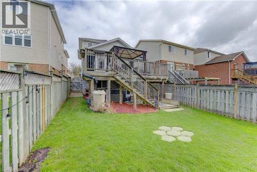 Rear exterior with wood deck and staircase, fenced perimeter, and green lawn space - 512 Hidden Creek Drive, Kitchener, ON - Outdoor With Deck Patio Veranda