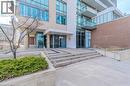 Modern building entrance featuring a prominent address number, glass doors, and a combination of brick and glass exterior - 85 Duke Street W Unit# 507, Kitchener, ON  - Outdoor With Balcony 