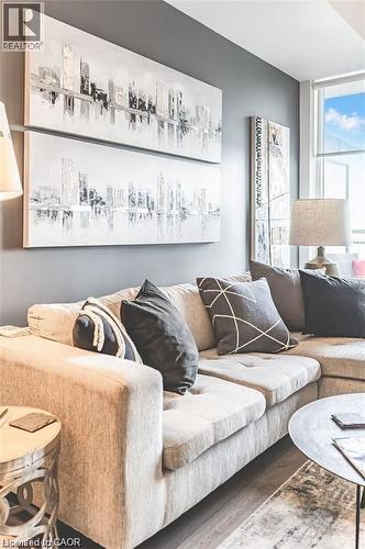 Living area featuring wood-finish flooring, a full-height window, and light gray walls - 85 Duke Street W Unit# 507, Kitchener, ON - Indoor Photo Showing Living Room