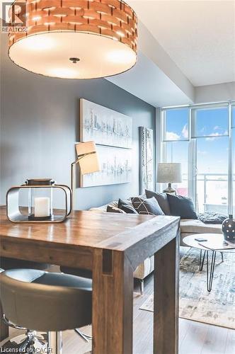 Open-concept living space with wood-finish flooring, a contemporary woven ceiling light fixture, and floor-to-ceiling windows - 85 Duke Street W Unit# 507, Kitchener, ON - Indoor