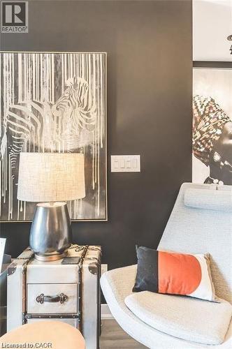 Dark accent wall providing a sophisticated backdrop, light wood-finish flooring, and a modern light switch panel - 85 Duke Street W Unit# 507, Kitchener, ON - Indoor Photo Showing Bedroom
