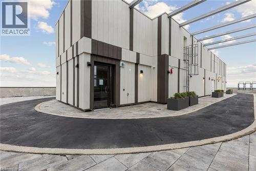 Rooftop structure featuring a modern facade with vertical white and brown paneling - 85 Duke Street W Unit# 507, Kitchener, ON - Outdoor With Exterior
