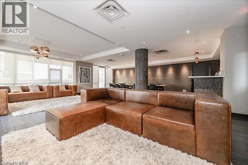 Spacious common area featuring dark wood-finish flooring, recessed lighting, and a textured accent wall - 85 Duke Street W Unit# 507, Kitchener, ON - Indoor Photo Showing Living Room