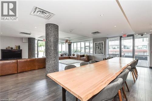 Spacious common area featuring wood-finish flooring and a natural edge wood table with seating - 85 Duke Street W Unit# 507, Kitchener, ON - Indoor