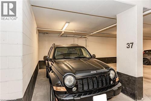 Designated parking space with concrete flooring and perimeter walls - 85 Duke Street W Unit# 507, Kitchener, ON - Indoor Photo Showing Garage