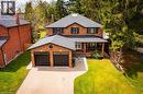 Brick-clad exterior featuring a two-car garage with black doors, a covered porch, a paver driveway, and a gabled roof - 1264 Kane Road, Mississauga, ON  - Outdoor 