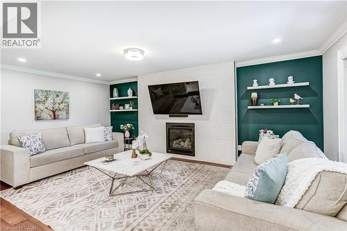 Living area featuring a modern fireplace with a textured white surround, recessed lighting, and crown molding - 1264 Kane Road, Mississauga, ON - Indoor Photo Showing Living Room With Fireplace