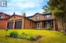 Brick exterior residence featuring a two-car garage with black paneled doors, a covered front porch with dark railings, and a white entry door with glass inserts - 1264 Kane Road, Mississauga, ON  - Outdoor With Deck Patio Veranda 