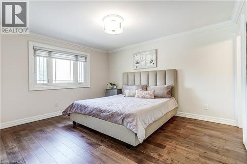 Bedroom featuring wood-finish flooring, a white window with horizontal blinds, extensive crown molding, baseboards, and a contemporary ceiling light fixture - 1264 Kane Road, Mississauga, ON - Indoor Photo Showing Bedroom
