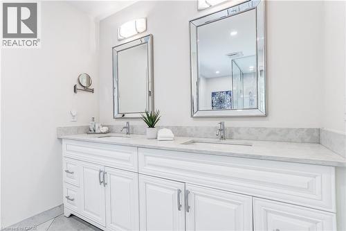 Dual white vanities featuring integrated sinks and stone-finish countertops - 1264 Kane Road, Mississauga, ON - Indoor Photo Showing Bathroom