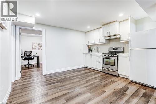 Kitchenette featuring white cabinetry, stainless steel range, white refrigerator, and wood-finish flooring - 1264 Kane Road, Mississauga, ON - Indoor Photo Showing Kitchen
