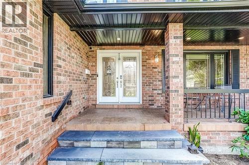 Brick facade with a covered porch featuring dual entry doors with decorative glass - 1264 Kane Road, Mississauga, ON - Outdoor