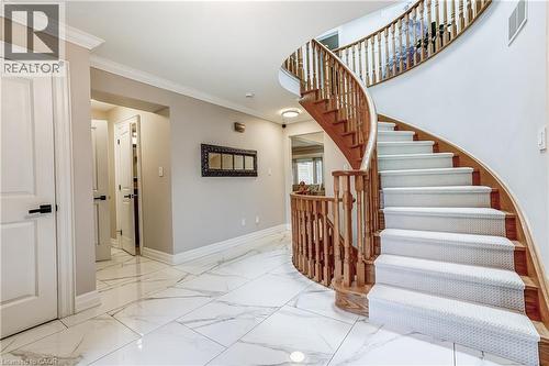 Grand curved staircase with wood banister and carpeted treads - 1264 Kane Road, Mississauga, ON - Indoor Photo Showing Other Room