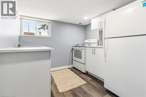 Basement kitchen with double sink, stove & full-size fridge - 29 Wexford Avenue N, Hamilton, ON - Indoor
