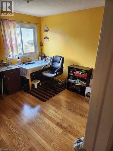 Hardwood flooring throughout the room, featuring a window with a white frame, and a built-in cabinetry desk unit - 1126 Copper Leaf Crescent, Kitchener, ON - Indoor