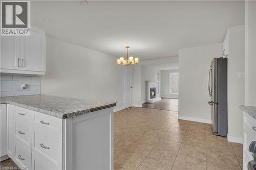 Open-concept kitchen with white shaker cabinetry, light-toned countertops, and subway tile backsplash - 22 Blackhorne Crescent, Kitchener, ON - Indoor Photo Showing Kitchen