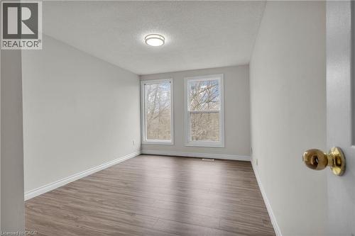 Bright interior space featuring wood-finish flooring, white baseboards, and light-toned walls - 22 Blackhorne Crescent, Kitchener, ON - Indoor Photo Showing Other Room