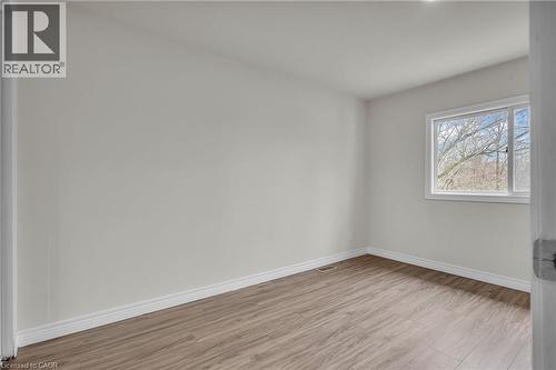 Spacious room with wood-finish flooring, light-colored walls, and a large window - 22 Blackhorne Crescent, Kitchener, ON - Indoor Photo Showing Other Room
