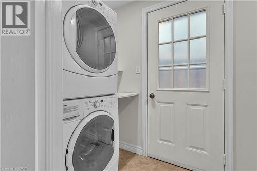 White stackable washer and dryer set, featuring front-loading machines - 22 Blackhorne Crescent, Kitchener, ON - Indoor Photo Showing Laundry Room