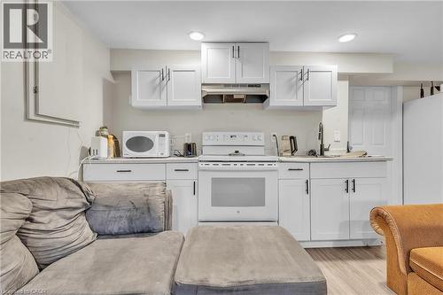 Compact kitchen space featuring white shaker-style cabinetry, white countertops, and a white range - 22 Blackhorne Crescent, Kitchener, ON - Indoor