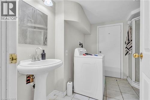 Bathroom featuring a pedestal sink with a chrome faucet, wall-mounted mirror, and tile flooring - 22 Blackhorne Crescent, Kitchener, ON - Indoor