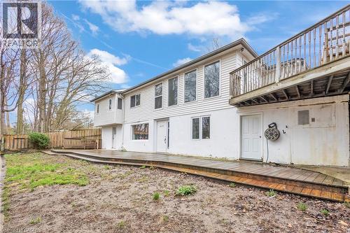 Exterior featuring white siding, multiple windows, an upper-level balcony, and a ground-level wooden deck - 22 Blackhorne Crescent, Kitchener, ON - Outdoor