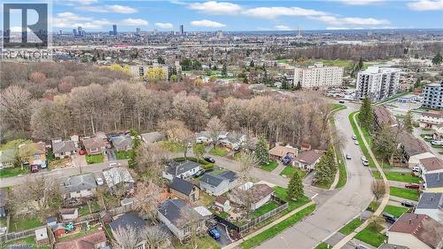 Aerial overview showcasing a residential street with single-story homes and a dense tree line - 22 Blackhorne Crescent, Kitchener, ON - Outdoor With View