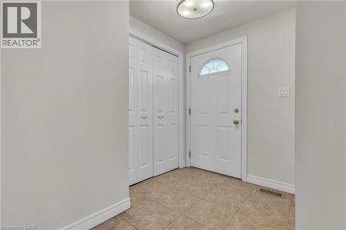 Entryway featuring neutral wall paint, tile flooring, a white paneled door with an arched glass insert, and bi-fold closet doors - 22 Blackhorne Crescent, Kitchener, ON - Indoor Photo Showing Other Room