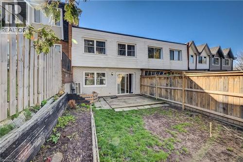 Rear exterior featuring a sliding glass door, white brick, and horizontal siding - 80 Heiman Street, Kitchener, ON - Outdoor