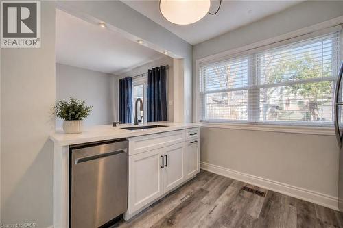 Kitchen workspace featuring white shaker cabinetry, stainless steel dishwasher, and quartz countertops with an undermount sink and matte black faucet - 80 Heiman Street, Kitchener, ON - Indoor