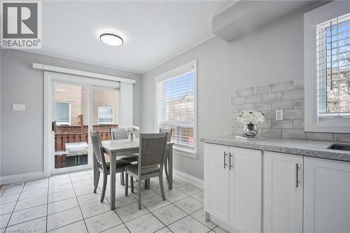 Bright eat-in kitchen area featuring white cabinetry, stone-finish countertops, and a subway tile backsplash - 5449 Rochelle Way, Mississauga, ON - Indoor Photo Showing Dining Room