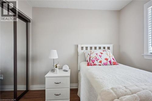 Room featuring wood-finish flooring, light-toned walls, and a window with white louvered shutters - 5449 Rochelle Way, Mississauga, ON - Indoor Photo Showing Bedroom