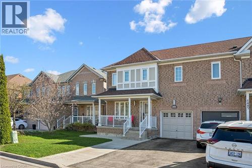 Brick exterior with light-colored siding accents, covered front porch, integrated garage, and driveway - 5449 Rochelle Way, Mississauga, ON - Outdoor With Deck Patio Veranda With Facade
