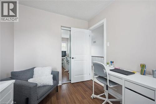 Interior room featuring light neutral wall paint, wood-finish flooring, a white built-in desk, and a white interior door with a paneled design - 5449 Rochelle Way, Mississauga, ON - Indoor Photo Showing Office
